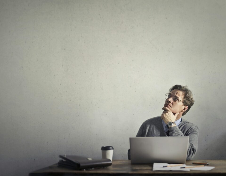 Man with pc looking up and thinking about something