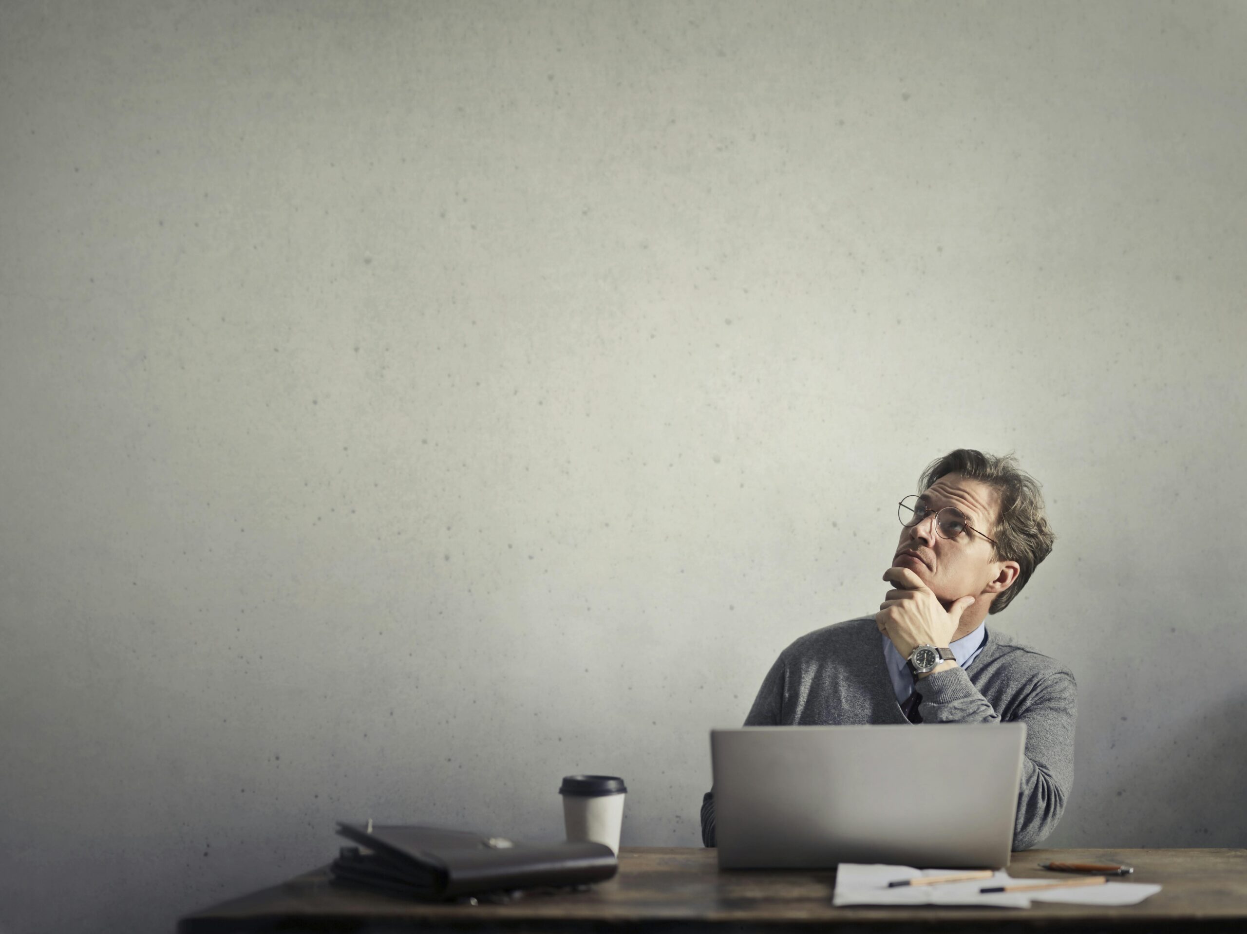 Man with pc looking up and thinking about something